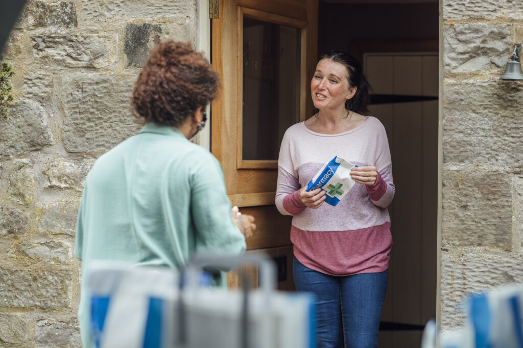 Pharmacist speaking with a patient at their home